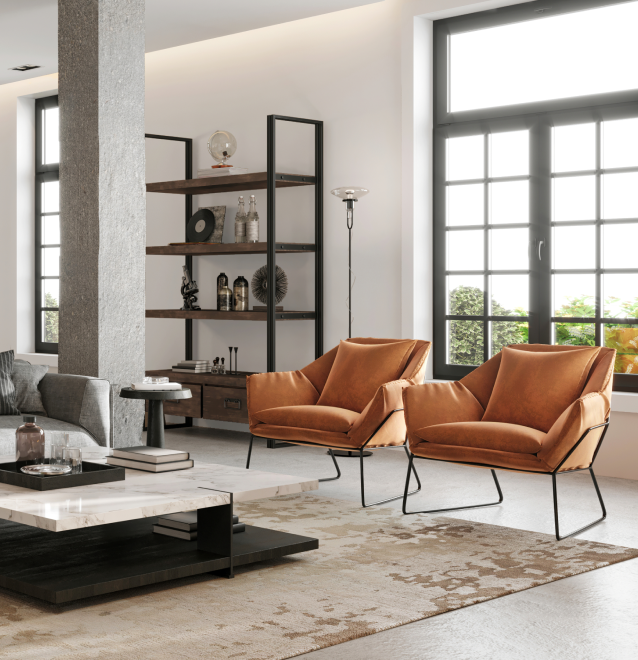 An industrial styled living area with two plush orange changes and a beautifully textured rug