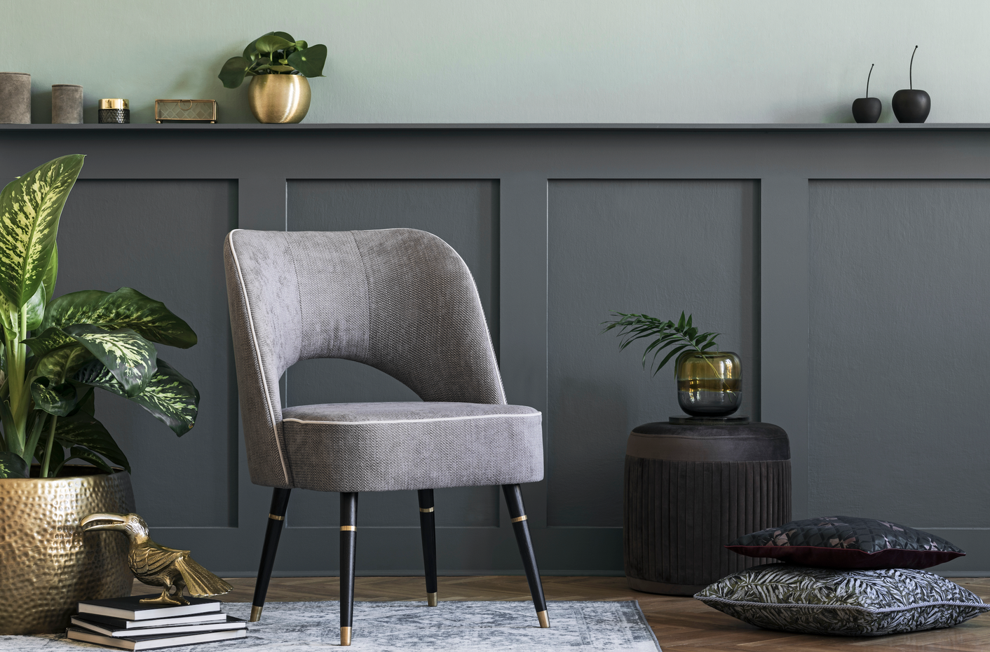 A grey occasional chair and some patterned cushions atop a beautifully textured rug